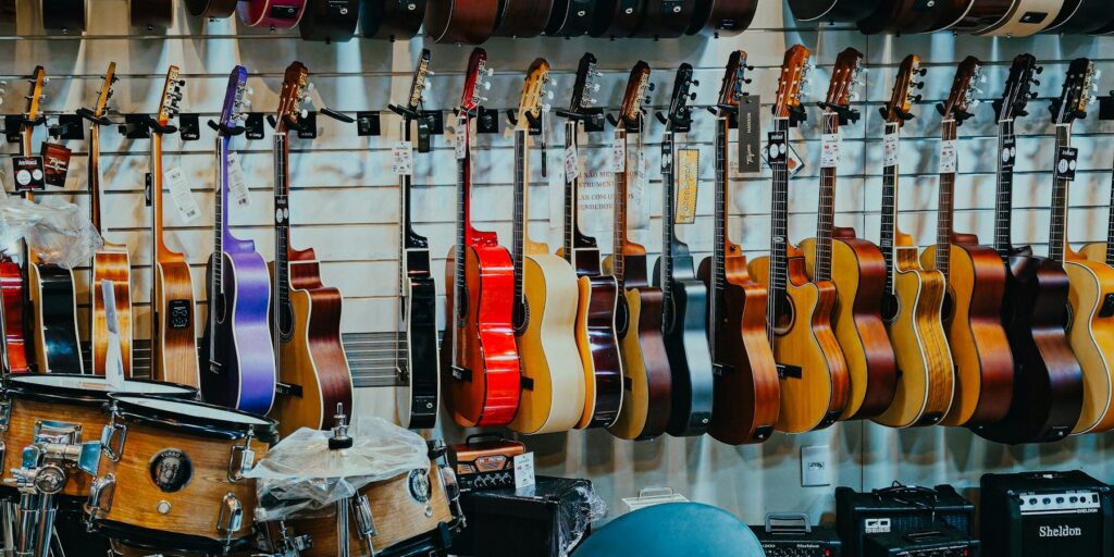 Guitar và trống trưng bày trong cửa hàng nhạc cụ, ảnh tham khảo cho Hoàng Long Music.